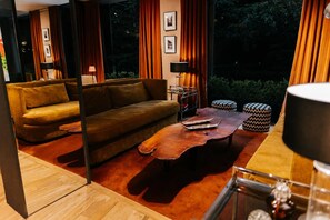 A modern living room with a sofa, a coffee table, and two ottomans. - Esplendor by Wyndham Buenos Aires Plaza Francia (Buenos Aires)