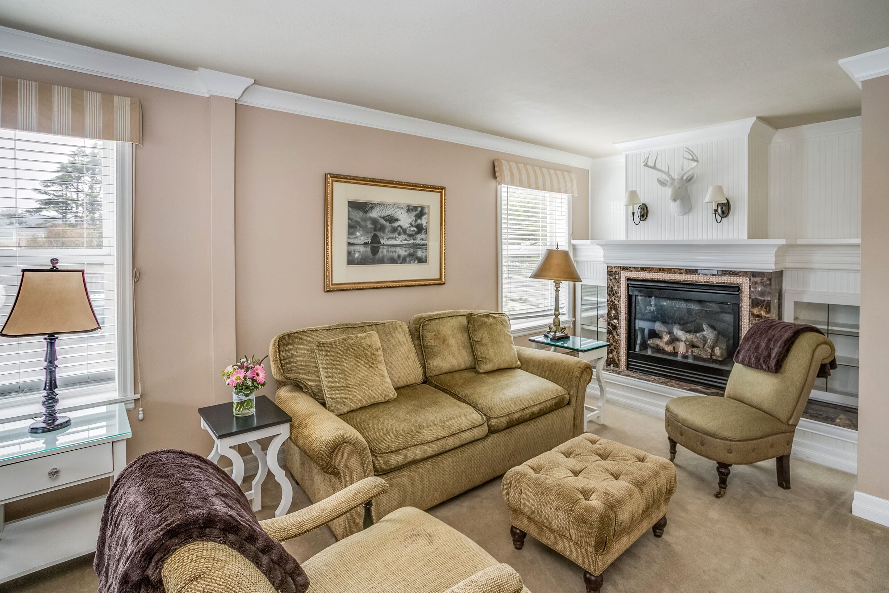 Una sala de estar con un sofá color crema, sillones y una chimenea.