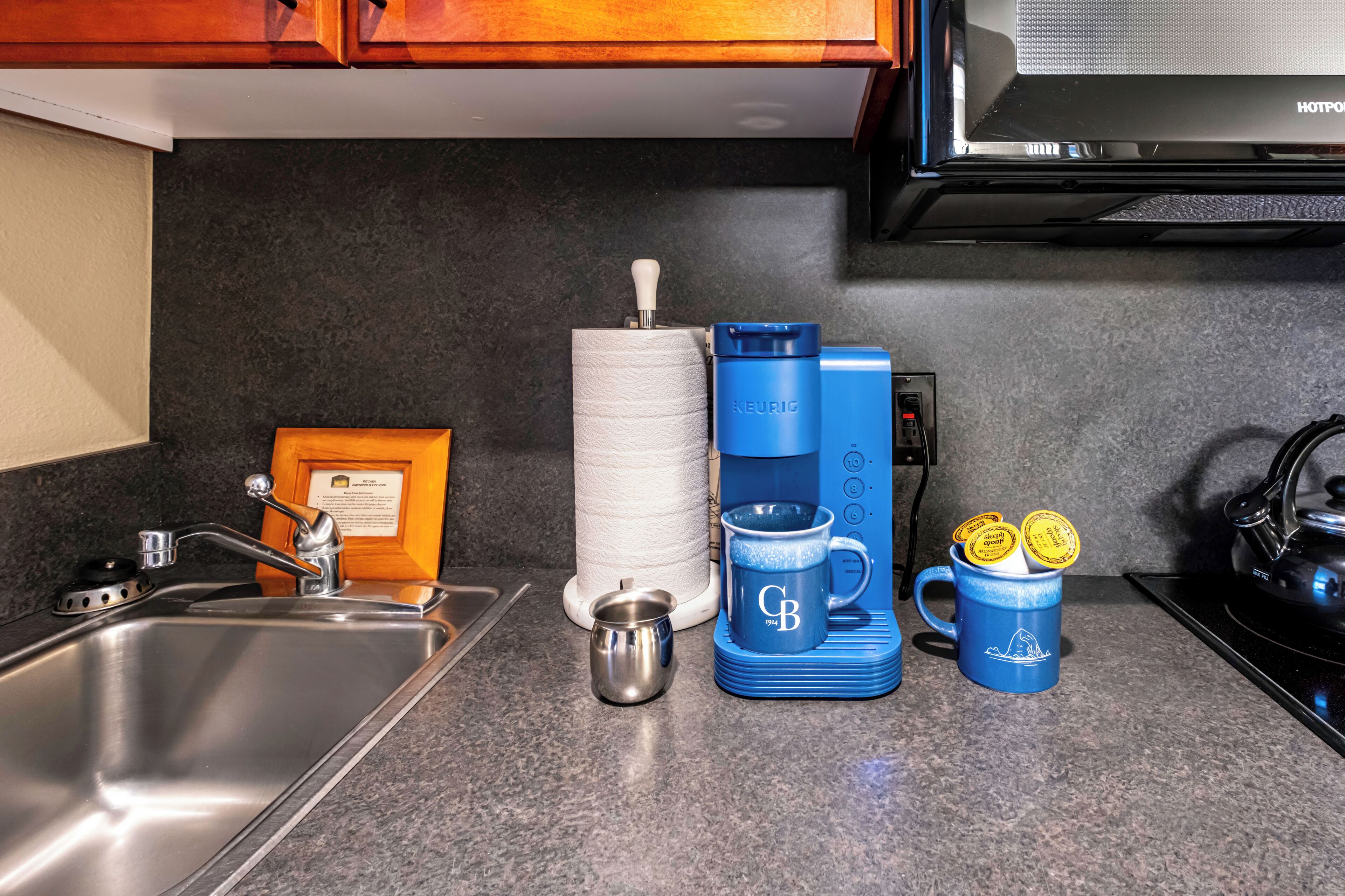 Uma cozinha com cafeteira, caneca e chaleira.