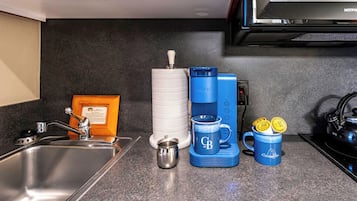 Eine Küche mit Kaffeemaschine, Tasse und Wasserkocher.