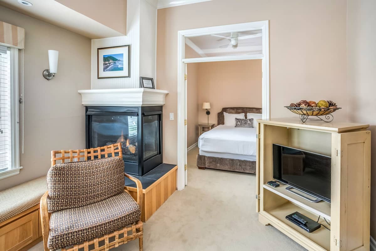 A cozy room with a fireplace, a television, a bed, and a dining area.