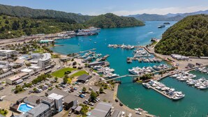 A marina with boats docked, surrounded by buildings and greenery. - Harbour View Motel (Picton)