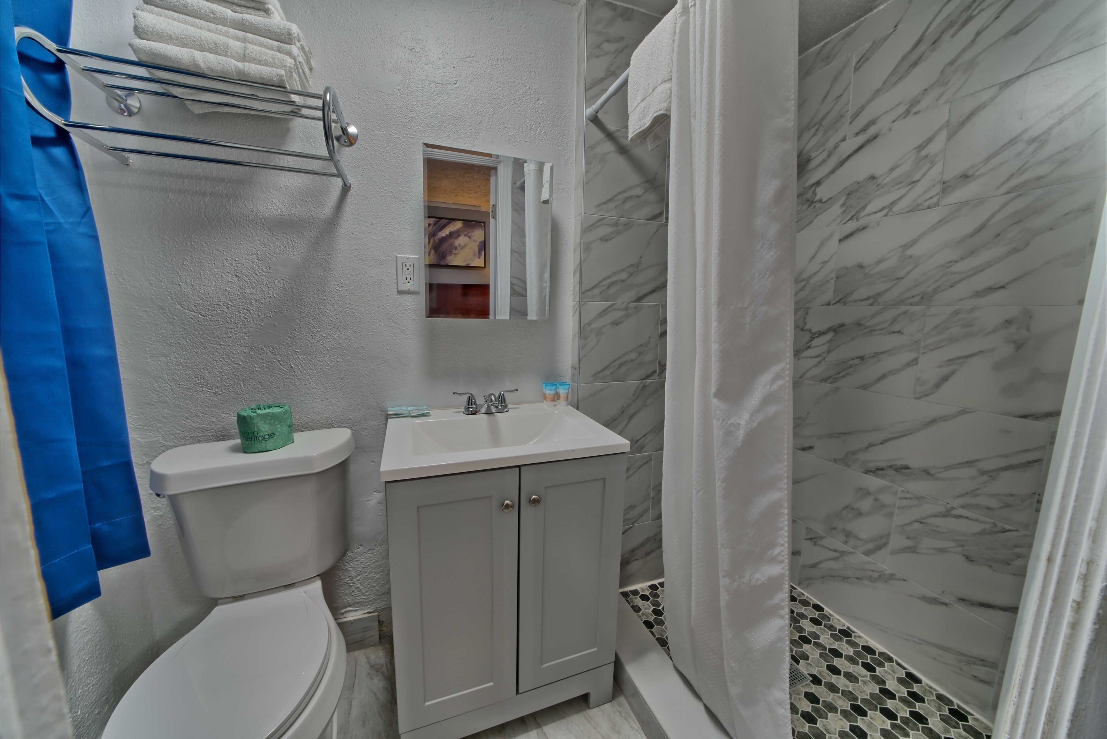 A bathroom with a toilet, sink, and shower area.