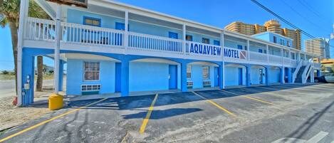 Un motel con fachada azul, varios balcones y un letrero.