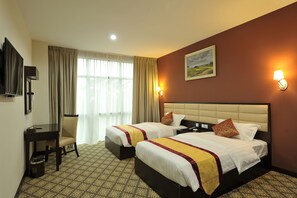 A hotel room with two beds, a desk, a chair, a television, and a painting on the wall. - Hallmark Regency Hotel - Johor Bahru (Johor Bahru)