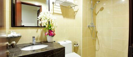 Un baño con lavamanos, inodoro y ducha.