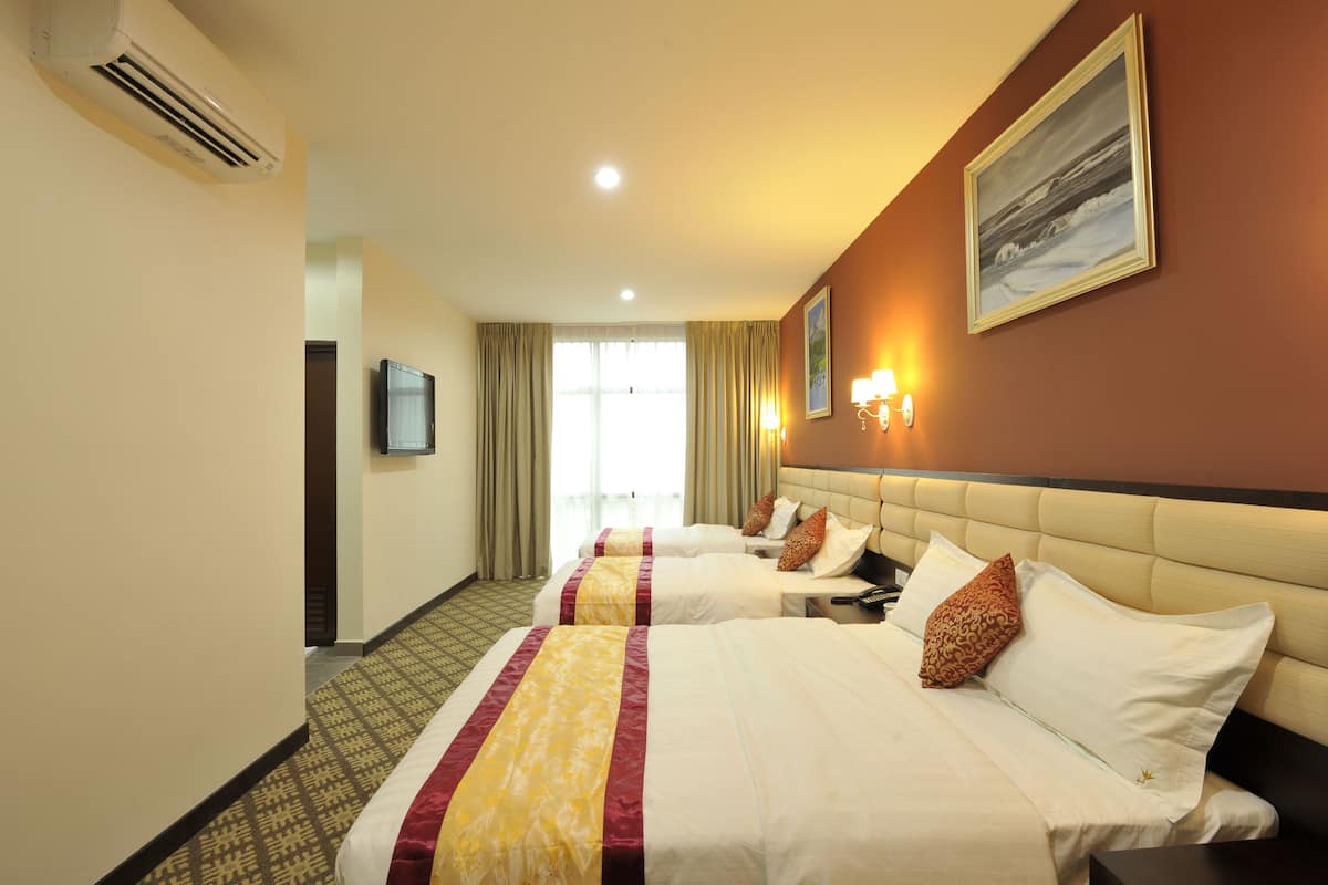 A hotel room with two beds, a television, a painting, and a window with curtains.