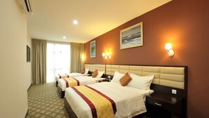 A hotel room with three beds, a large window with curtains, wall-mounted lamps, and a painting. - Hallmark Regency Hotel - Johor Bahru (Johor Bahru)