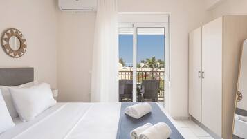A hotel room with a bed, a balcony with a view, and a wardrobe.