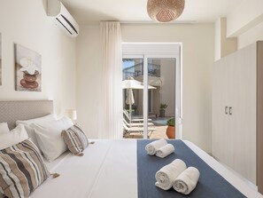 Habitación de hotel con cama, vista al exterior y balcón.