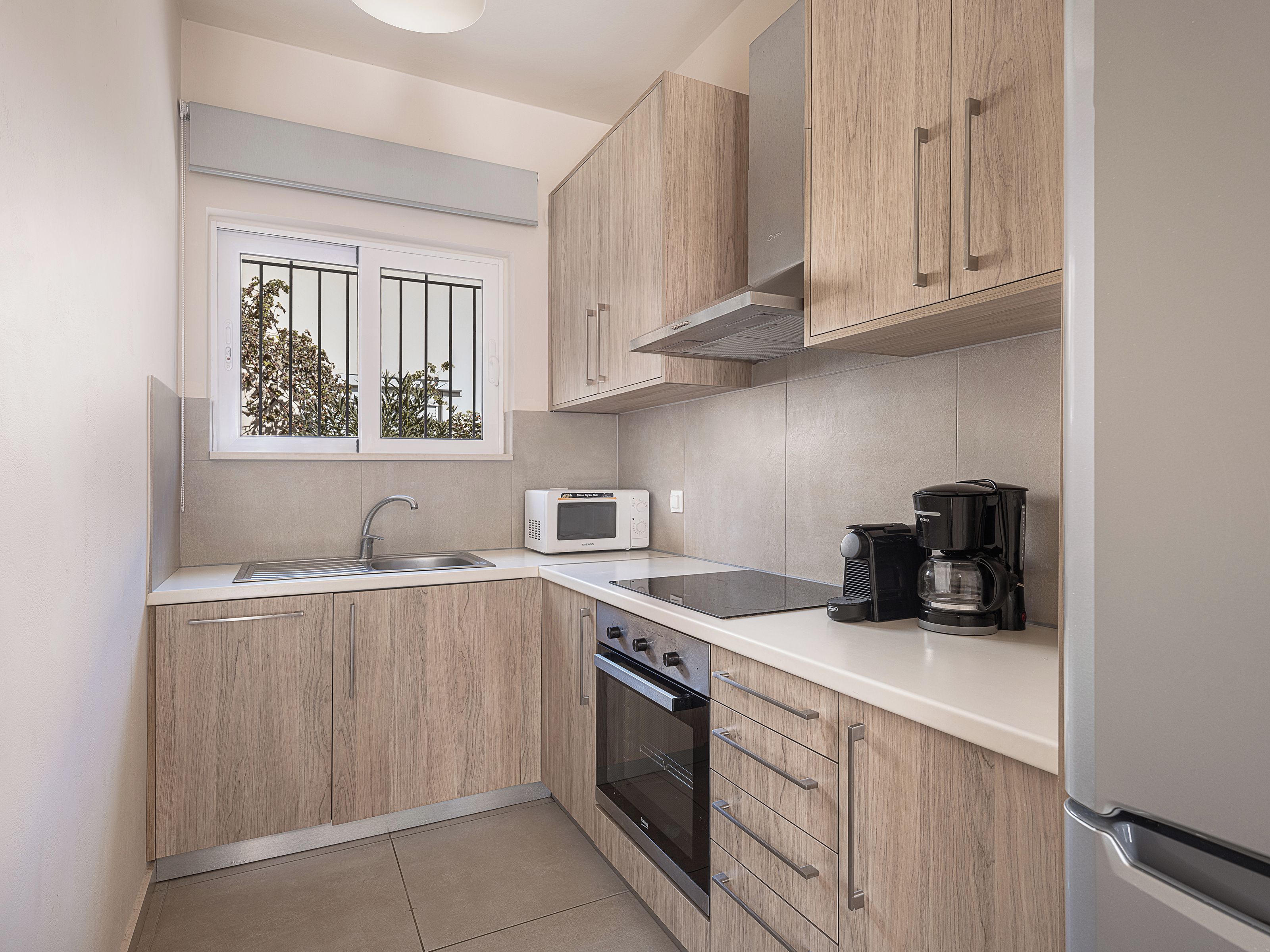 A compact kitchen with a microwave, coffee maker, and oven.