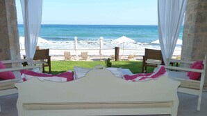Ein Bett mit Blick auf den Strand und den Ozean.