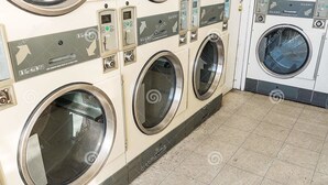 A row of front-loading washing machines in a commercial laundry room. - Canada Easy Lodge (Burnaby)