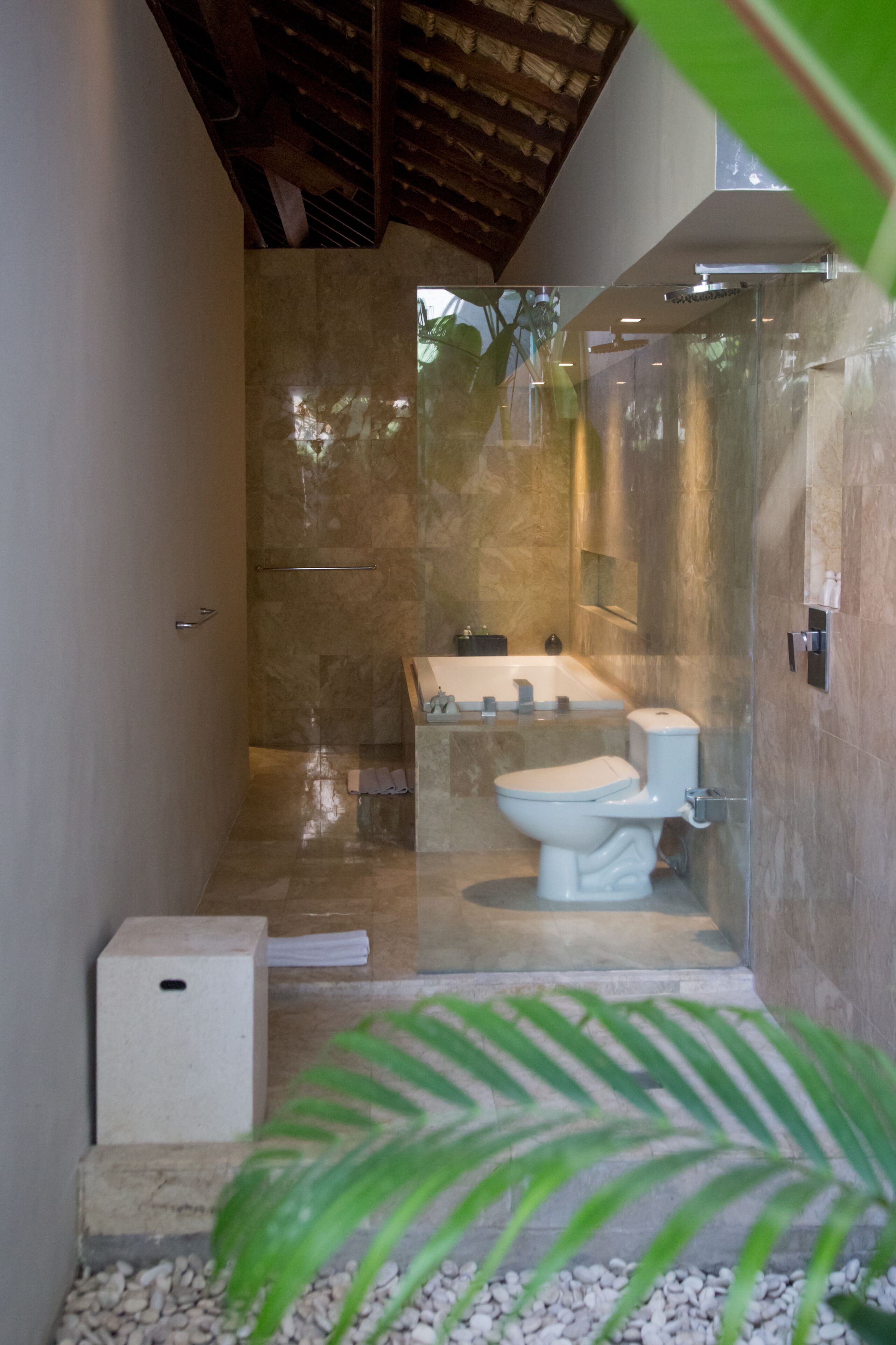 A modern bathroom with a glass-enclosed shower, a white toilet, and a bathtub.