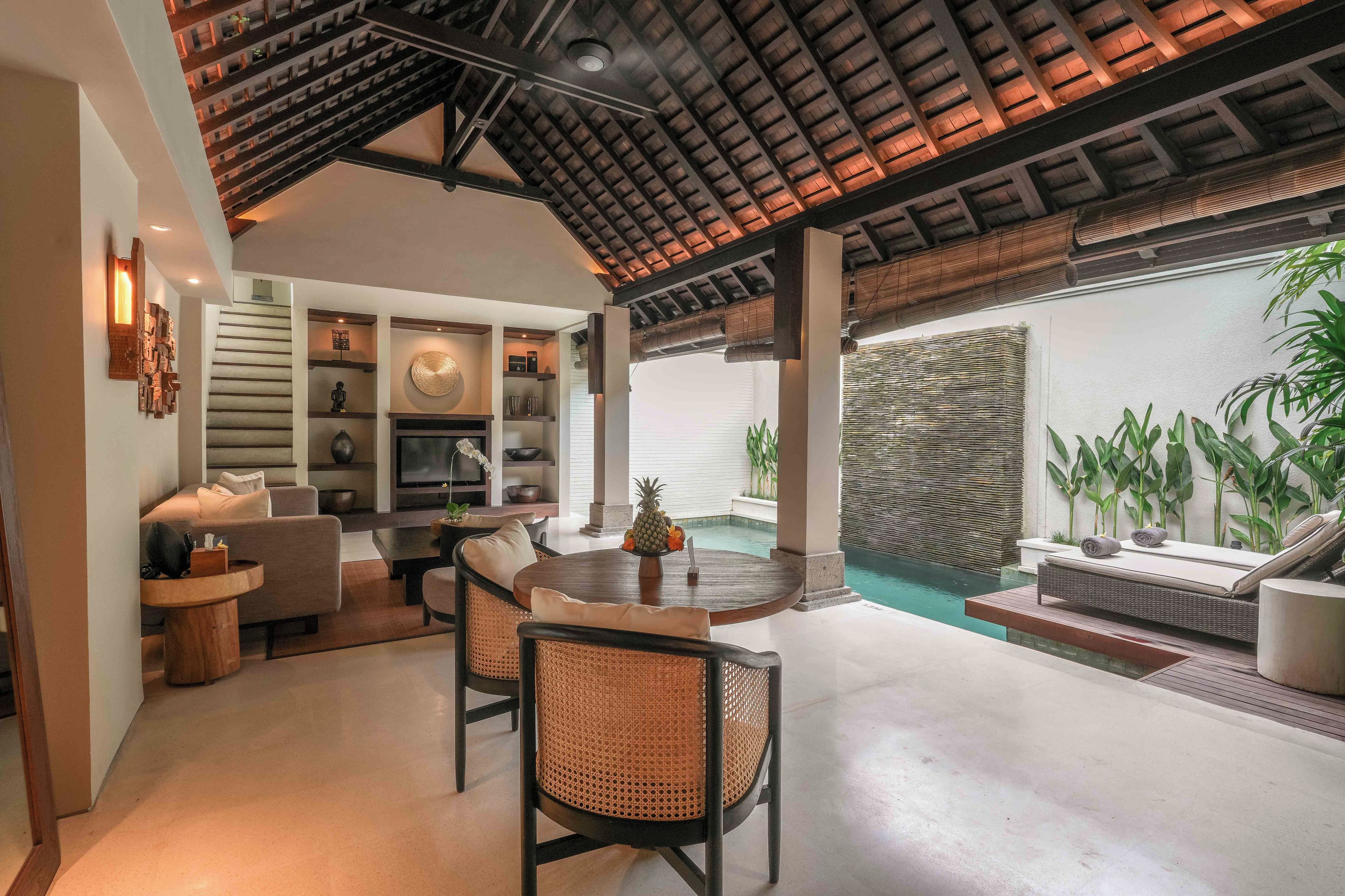 Un interior moderno con comedor, asientos y vistas a una piscina.