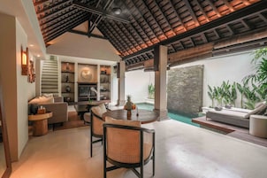 A modern interior with a dining area, seating, and a view of a pool.