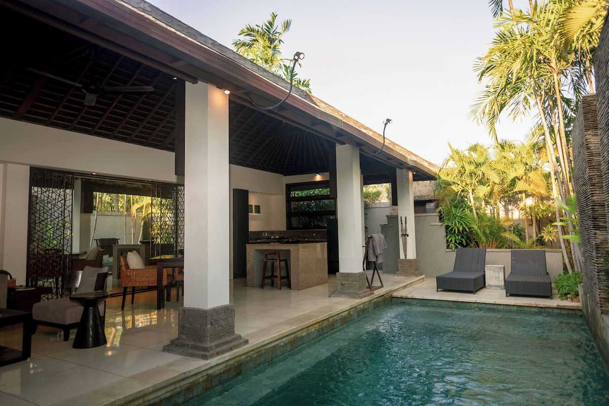 A poolside area with a bar, seating, and a covered outdoor space.