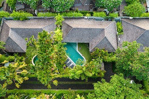 A resort with multiple buildings, a swimming pool, and lush greenery.