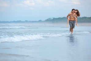 Perto da praia, areia branca, espreguiçadeiras, guarda-sóis