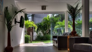 Una sala de estar moderna con un ventanal que da a un jardín. Hay dos sofás y una mesita de centro.