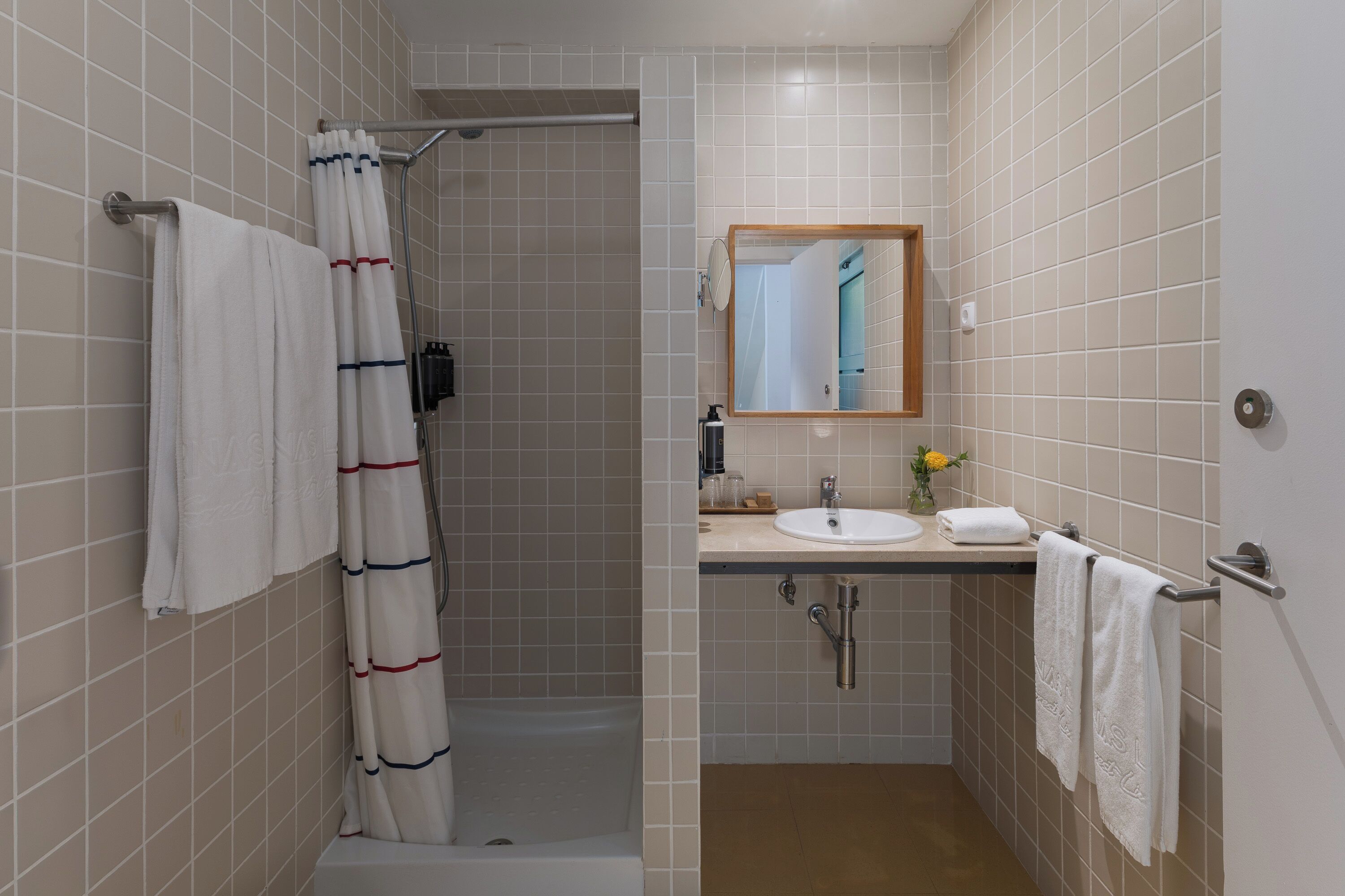 Un baño con ducha, lavabo y espejo.