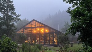Un edificio moderno con techo de vidrio y un área de comedor visible en su interior.