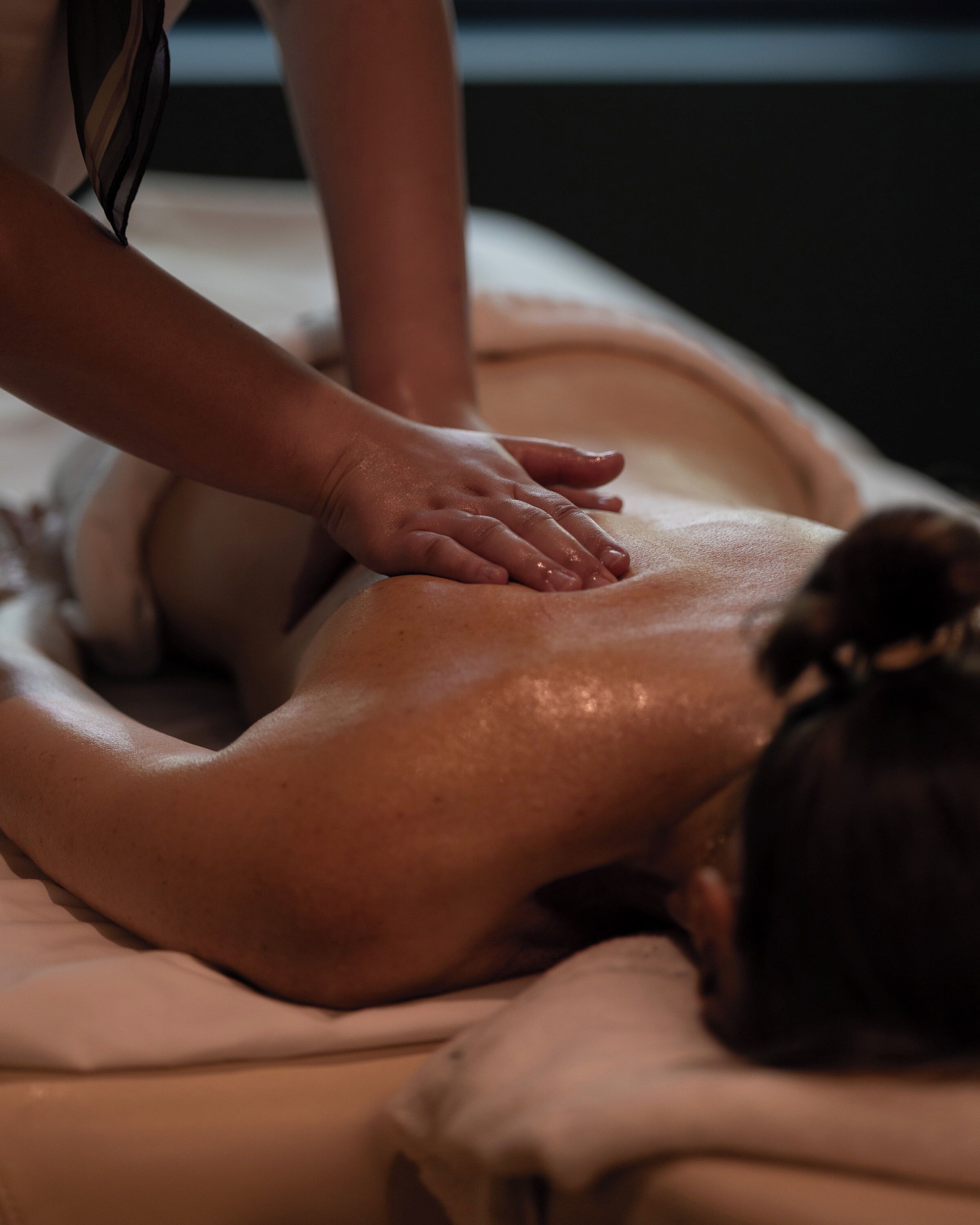 A person receiving a massage on a bed.