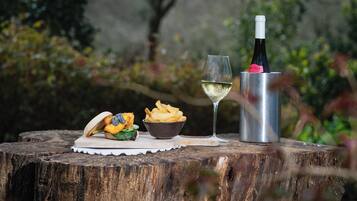 A meal with a sandwich and fries on a wooden table outdoors.