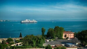 A large cruise ship on a calm sea with a clear sky. - Mytra Hotel (Istanbul)