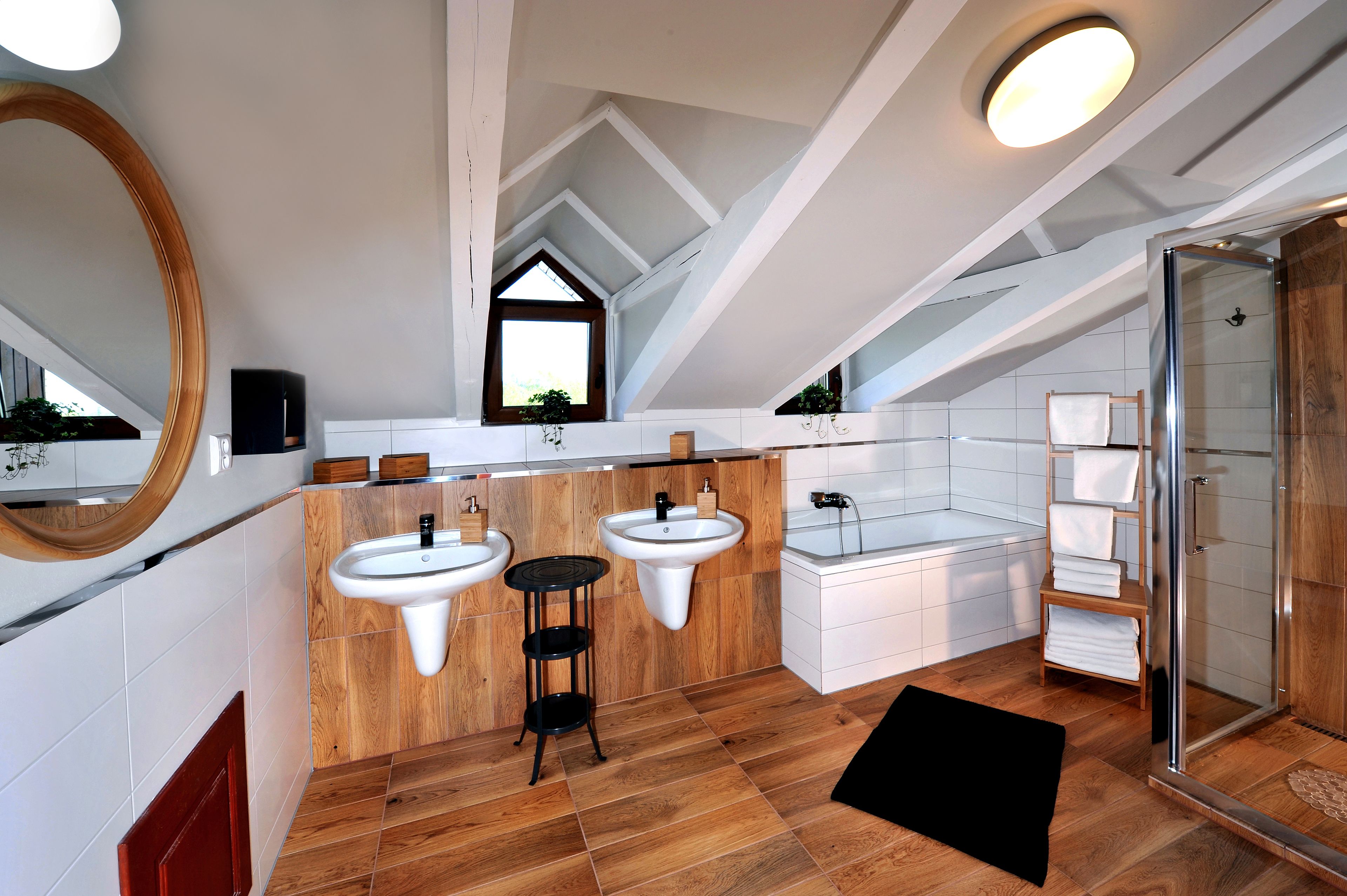A modern bathroom with two sinks, a bathtub, and a shower.