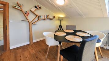 A dining area with a black table, white chairs, and woven placemats.