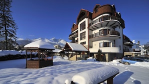 Un edificio de varios pisos con balcones y un suelo cubierto de nieve.