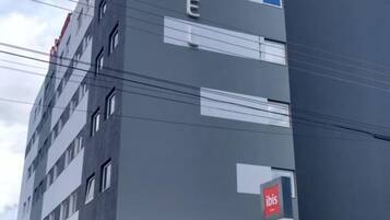 Een modern hotelgebouw met het 'ibis'-logo en 'HOTEL'-aanduiding.