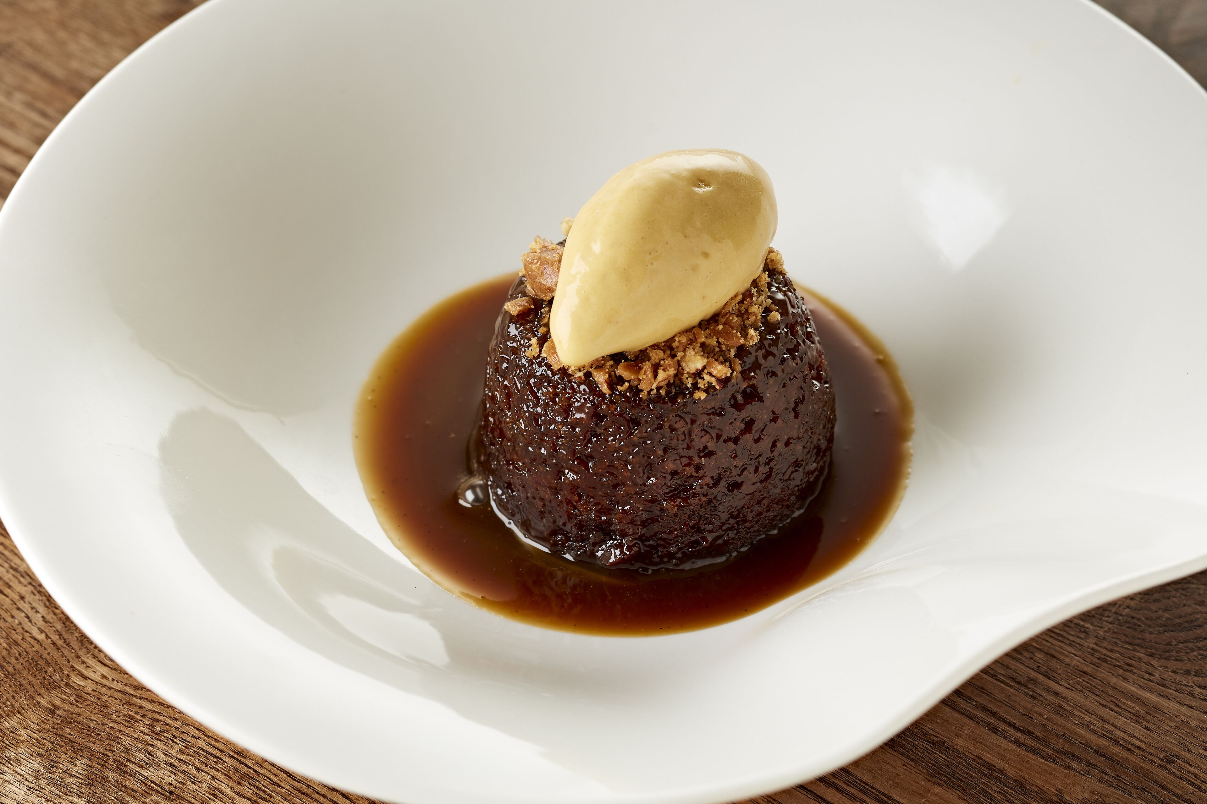A dessert on a white plate with a caramel sauce.