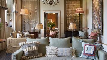 A cozy living room with a sofa set, decorative lamps, and a chandelier.