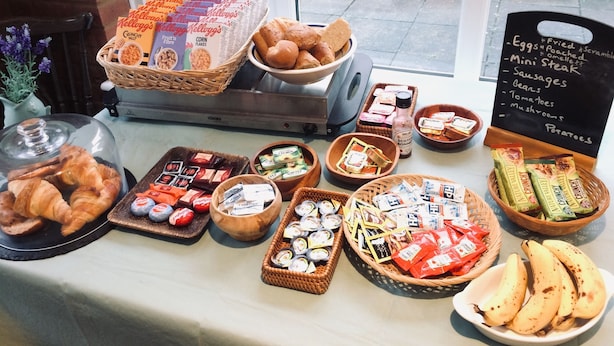 A breakfast buffet with various food items and condiments. - Bartles Lodge (Dereham)