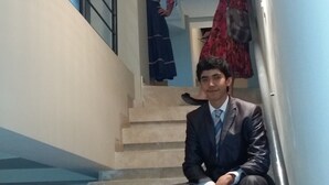 A man in a suit sitting on a staircase.