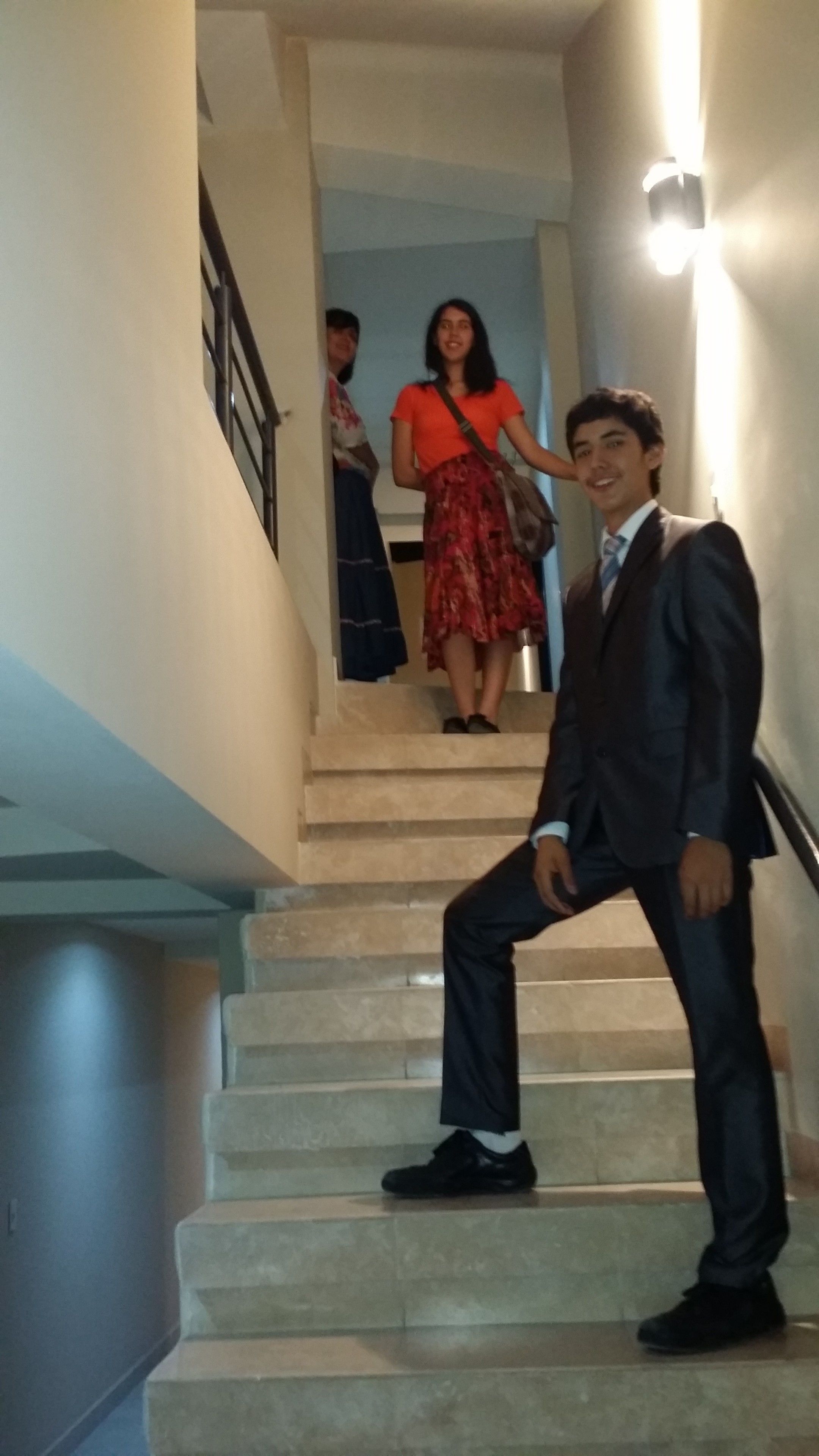 A staircase with a person in a suit and another in a red dress.