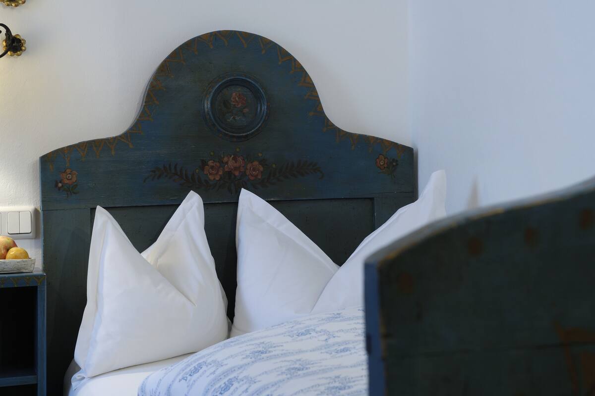 Una cama con almohadas blancas y un cabecero azul.
