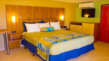 Quarto de hotel com cama, mesas de cabeceira, escrivaninha e guarda-roupa.