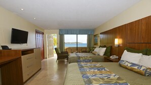 A hotel room with a bed, a desk, a television, and a view of the sea. - Lindbergh Bay Hotel and Villas (St. Thomas)