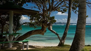 Nära stranden, vit sandstrand, solstolar och strandhanddukar