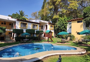 Una piscina al aire libre, sillones reclinables de piscina