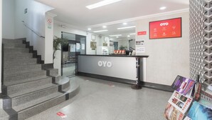 A reception area with a staircase, a reception desk, and a wall-mounted display. - Mangabeiras Hotel (Goiania)