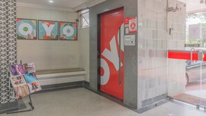 A hotel lobby with a red door, a bench, and a magazine rack. - Mangabeiras Hotel (Goiania)
