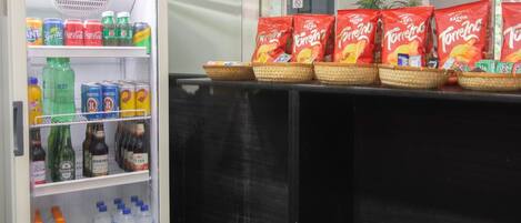 Ein Getränke- und Snackautomat, gefüllt mit Snacks wie Doritos und verschiedenen Erfrischungsgetränken.