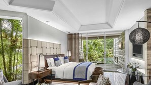 A modern bedroom with a large bed, a glass table, and a view of lush greenery. - Sofitel Bali Nusa Dua Beach Resort (Nusa Dua)