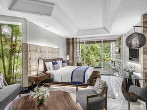 A modern bedroom with a large bed, a glass table, and a view of lush greenery. - Sofitel Bali Nusa Dua Beach Resort (Nusa Dua)