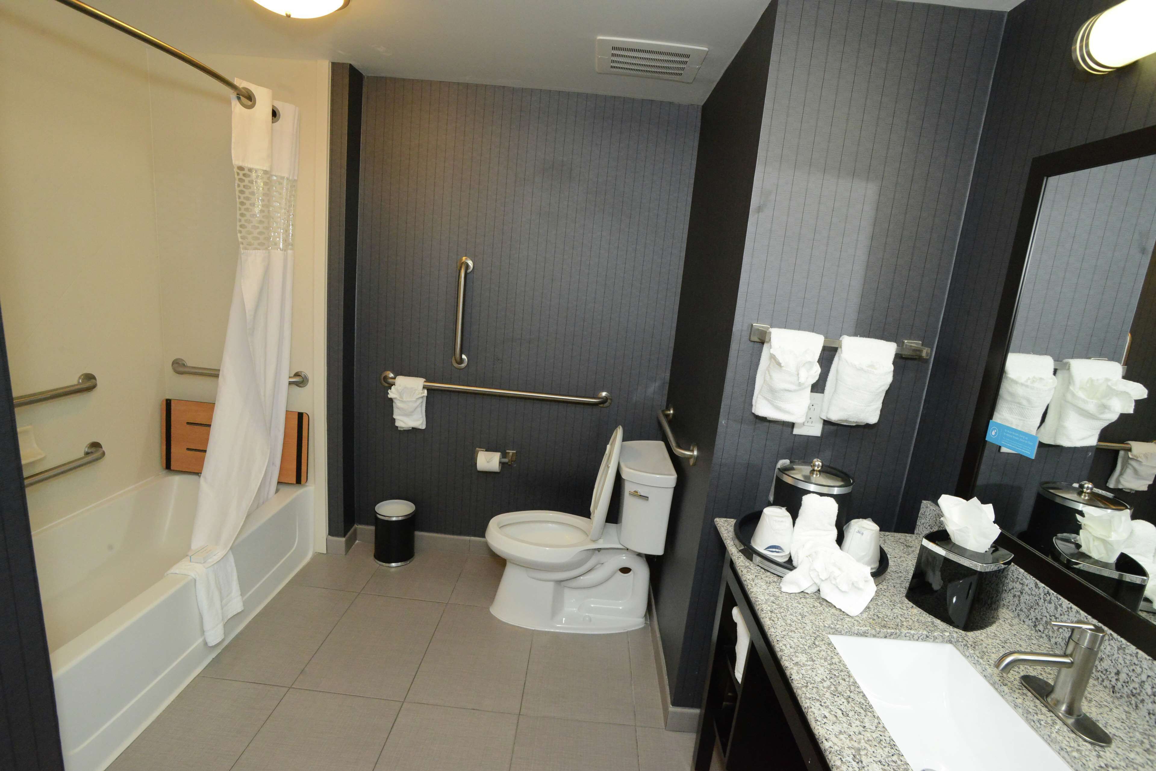 A modern bathroom with a bathtub, toilet, and sink.
