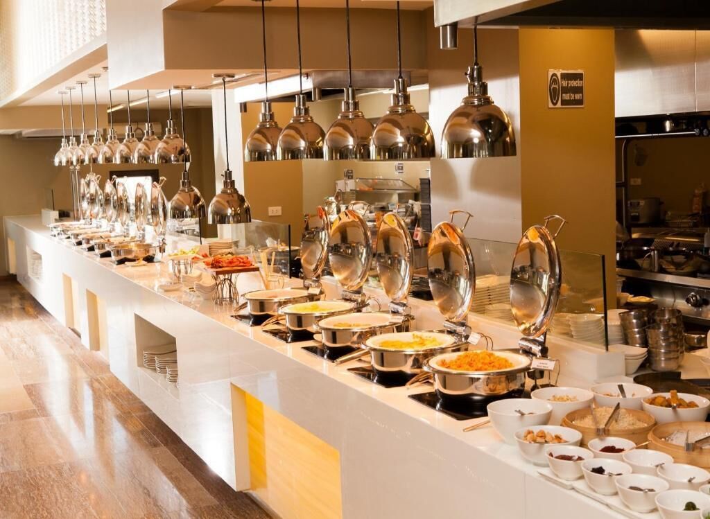 A buffet setup with various food stations and hanging lights.